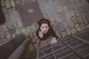 woman-stretching-up-on-ladder