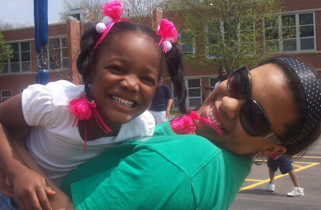 young-girl-smiling-while-being-held-by-Mizzou-PALS-tutor