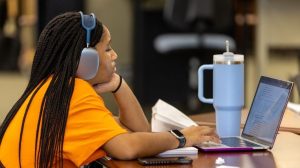 MU-student-with-headphones-and-laptop-at-library