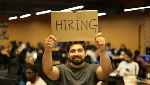 man holding hiring sign