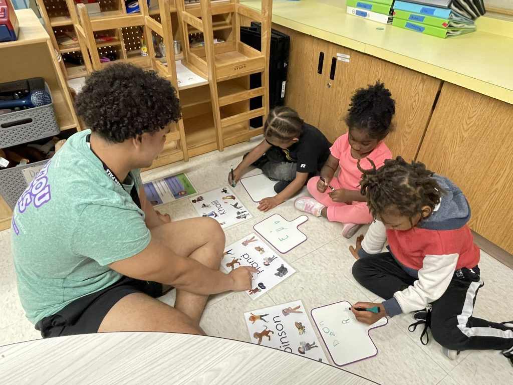 Mizzou PALS tutor doing phonics with kids