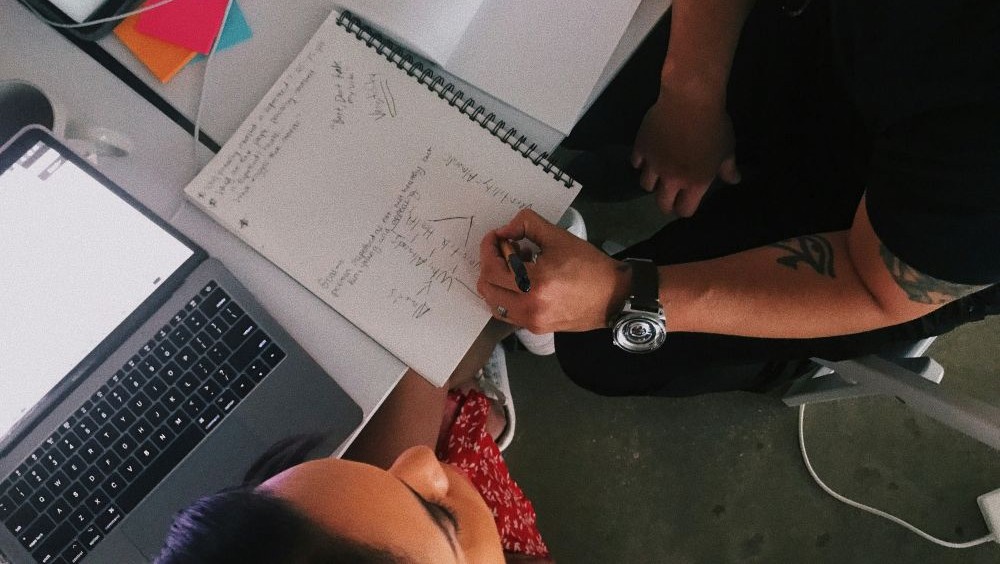 boss and intern talking over notes