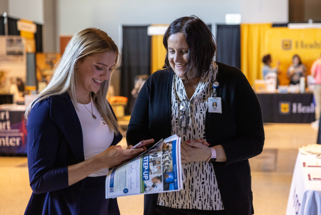 mu student siling at career fair employer