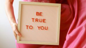 handheld sign saying Be true to you
